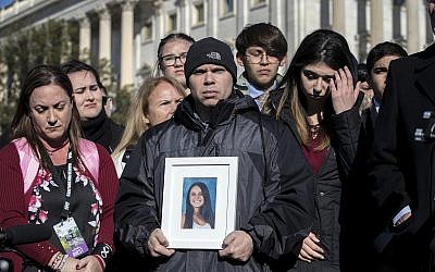 Ilan Alhadeff, joined at left by his wife Lori Alhadeff, holds a photograph of their daughter, Alyssa Alhadeff, 14, who was killed at Marjory Stoneman Douglas High School in Parkland, Fla., during a rally in support of gun control at the U.S. Capitol in Washington, Friday, March 23, 2018. (AP Photo/J. Scott Applewhite)