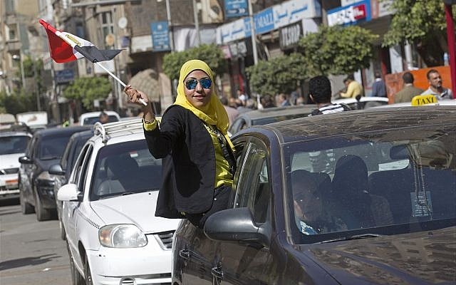 A woman waves an Egyptian national flag as she hangs out a car window outside a polling station in Cairo, Egypt, Monday, March 26, 2018. (AP Photo/Amr Nabil) A woman waves an Egyptian national flag as she hangs out a car window outside a polling station in Cairo, Egypt, Monday, March 26, 2018. (AP Photo/Amr Nabil)