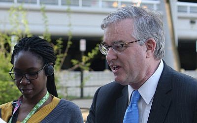 David Trone, right, owner of wine superstore chain Total Wine and More, greets commuters at the Shady Grove Metro station, in Derwood, Md., on Wednesday, April 20, 2016. (AP Photo/Brian Witte)