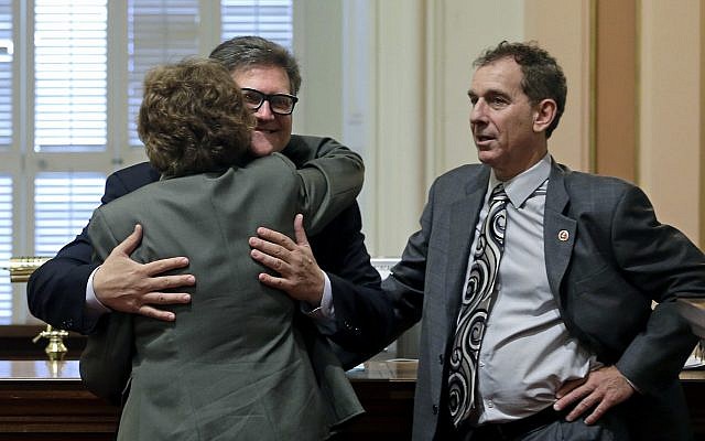 In this April 30, 2015 file photo, state Sen. Bob Hertzberg, center, gives Sen. Lois Wolk, a hug as Sen. Bob Wieckowski, looks on at the Capitol in Sacramento, Calif. (AP Photo/Rich Pedroncelli) In this April 30, 2015 file photo, state Sen. Bob Hertzberg, center, gives Sen. Lois Wolk, a hug as Sen. Bob Wieckowski, looks on at the Capitol in Sacramento, Calif. (AP Photo/Rich Pedroncelli)
