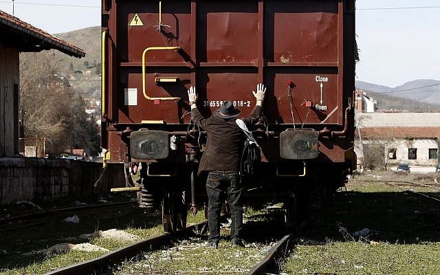 A Jew puts his arms on a freight wagon, during a commemoration for the victims of the Holocaust at the railway station in Bitola, southern Macedonia, on March 11, 2018. (AP Photo/Boris Grdanoski)