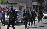 Masked gunmen from the Izz a-Din al-Qassam Brigades, the military wing of the Hamas terror group, march with their weapons during a large-scale drill across the Gaza Strip, March 25, 2018. (AP Photo/ Khalil Hamra)