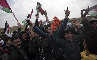 Palestinians chant slogans as they protest against Israel near the Gaza Strip border, in eastern Gaza City, Friday, March 30, 2018. (AP Photo/Khalil Hamra)