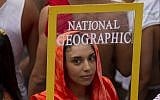 A reveler holds a frame depicting a front page of National Geographic magazine during "Ceu na Terra" block carnival parade in Rio de Janeiro, Brazil, Saturday, February 9, 2013. (AP Photo/Silvia Izquierdo)