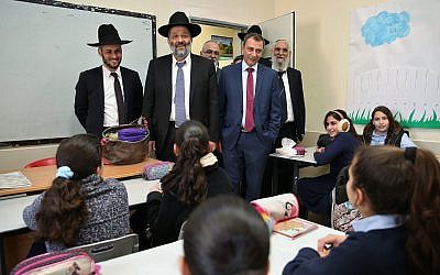Tiberias mayor Yossi Ben-David (right, without hat), with Interior Minister  Aryeh Deri (center) during a visit to schools in the northern Israeli city of Tiberias, December 20, 2016. (Yaacov Cohen/Flash90)