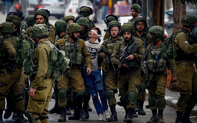 16-year-old Fawzi al-Junaidi (c) is arrested by Israeli soldiers at a protest in Hebron, December 7, 2017. (Wisam Hashlamoun/Flash90)
