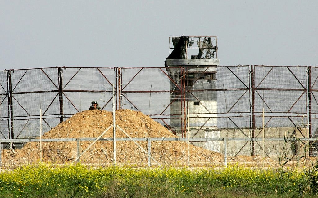 An Israeli soldier watches Palestinian protesters during clashes with Israeli soldiers near the Israel-Gaza border, east of Khan Younis in the southern Gaza Strip, March 2, 2018. (Abed Rahim Khatib/Flash90)