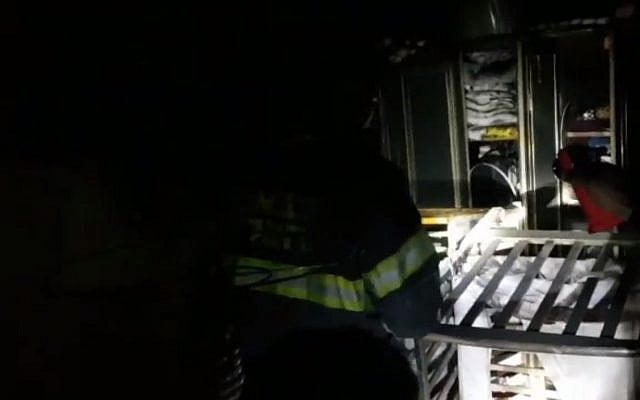 Firefighters examine the destruction in a children's bedroom after a blaze in a Beersheba apartment, March 25, 2018. (Screen capture: Ynet news) Firefighters examine the destruction in a children's bedroom after a blaze in a Beersheba apartment, March 25, 2018. (Screen capture: Ynet news)