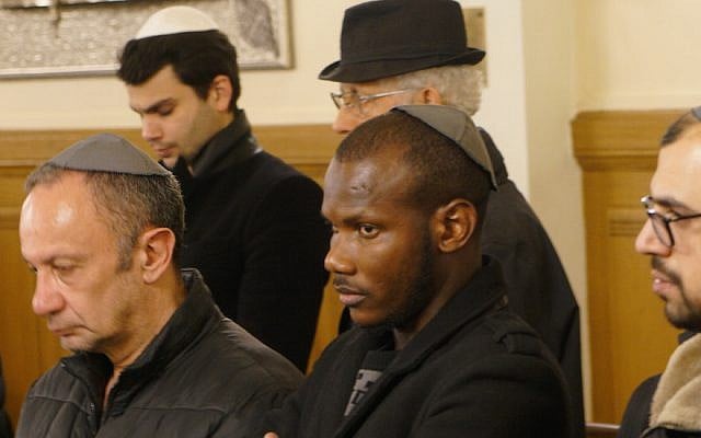 Lassana Bathily praying with members of the Jewish community at the Tournelles Synagogue in Paris, March 28, 2018. (Cnaan Liphshiz, JTA)