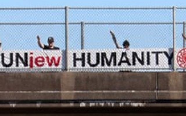 White supremacists hang an anti-Semitic banner on a highway overpass that reads 'UnJew Humanity' (Courtesy: Anti-Defamation League) White supremacists hang an anti-Semitic banner on a highway overpass that reads 'UnJew Humanity' (Courtesy: Anti-Defamation League)