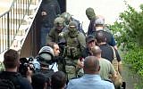 Israeli security officials drag an assailant into custody after he attacked two police officers and an elderly couple in their Haifa apartment before barricading himself inside on March 12, 2018. (Screen capture/Hadashot news)