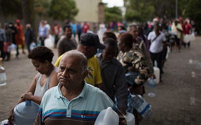 Cape Town residents residents wait to fill containers with water at a source for natural spring water, February 2, 2018.(AP Photo/Bram Janssen)