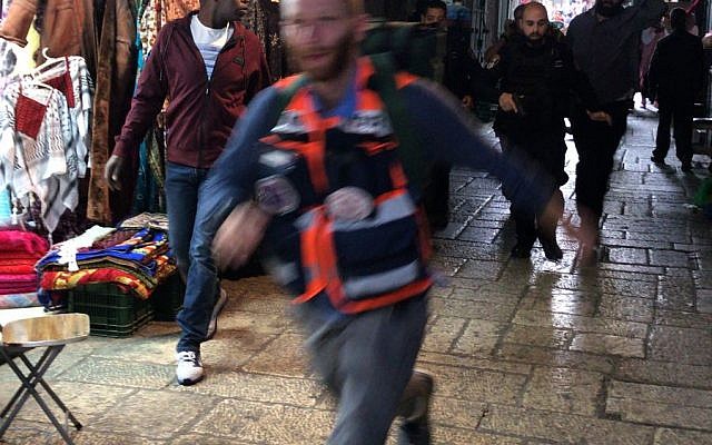 A Medic rushes tend to an Israeli victim of a stabbing attack in the Old City of Jerusalem on March 18, 2018. (Ir Amim)