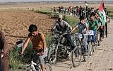 Palestinian children ride bikes near the border with Israel on the outskirts of Khan Yunis in the southern Gaza Strip, as they take part in a cycling race demanding a 'Right of Return' for millions to Israel on March 26, 2018. (AFP/Said Khatib)