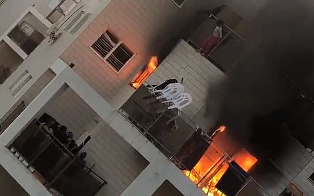 An eight-year-old girl leaps from a blaze on the eighth floor to safety on the sixth floor of a Beersheba apartment block on March 25, 2018. (Screen capture: Ynet news)