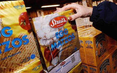 An illustrative photo of a shopper at a grocery store picking up a box of matzah. (William Thomas Cain/Getty Images/via JTA)