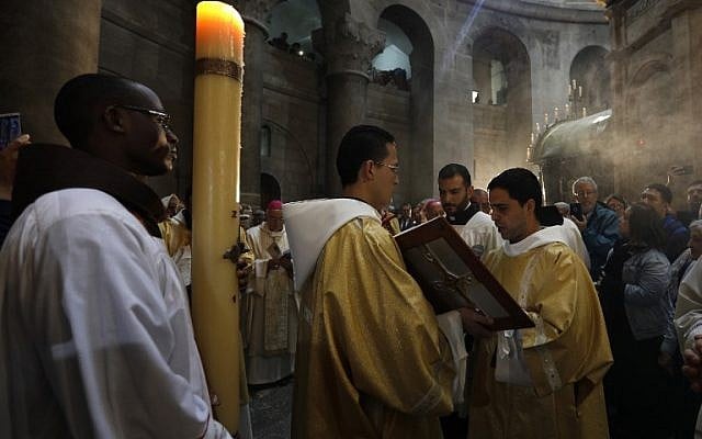 Roman Catholic clergymen pray during the Easter Sunday procession on April 1, 2018, at the Church of the Holy Sepulchre. (AFP PHOTO / GALI TIBBON) Roman Catholic clergymen pray during the Easter Sunday procession on April 1, 2018, at the Church of the Holy Sepulchre. (AFP PHOTO / GALI TIBBON)