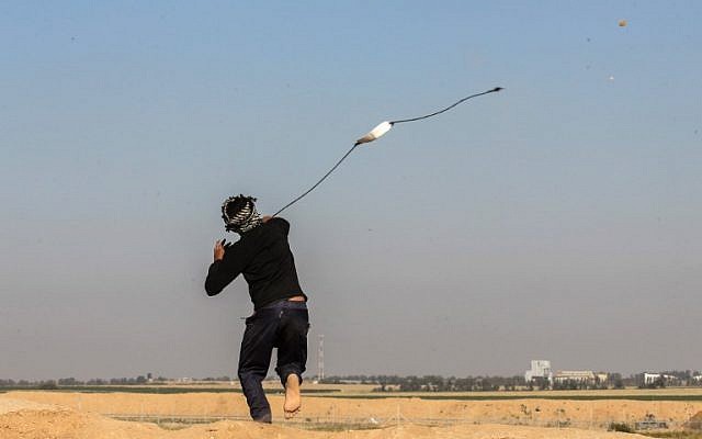 A Palestinian man swings a slingshot during clashes with Israeli security forces near the border with Israel, east of Khan Younis, in the southern Gaza Strip, on April 1, 2018. (AFP/ SAID KHATIB) A Palestinian man swings a slingshot during clashes with Israeli security forces near the border with Israel, east of Khan Younis, in the southern Gaza Strip, on April 1, 2018. (AFP/ SAID KHATIB)