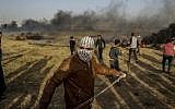 A Palestinian protestor uses a slingshot to throw a stone during clashes with Israeli forces following a tent city gathering at the Israel-Gaza border east of Gaza City on April 4, 2018. (AFP  MAHMUD HAMS)