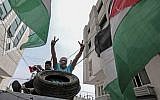 Palestinian men sit in a trailer loaded with tires to be used in protests in Rafah, in the southern Gaza Strip, on April 5, 2018. (AFP /SAID KHATIB)