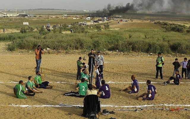 Disabled Palestinians play volleyball near to the site of clashes between Palestinian demonstrators and Israeli security forces following a protest along the Gaza-Israel border, east of Gaza City on April 5, 2018. (AFP/MOHAMMED ABED) Disabled Palestinians play volleyball near to the site of clashes between Palestinian demonstrators and Israeli security forces following a protest along the Gaza-Israel border, east of Gaza City on April 5, 2018. (AFP/MOHAMMED ABED)