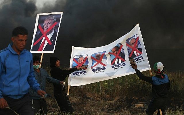 Palestinian protesters hold posters bearing images of Israeli politicians and the US president during clashes with Israeli security forces following a protest along the border with Israel, east of Gaza City on April 5, 2018 ( AFP PHOTO / MOHAMMED ABED) Palestinian protesters hold posters bearing images of Israeli politicians and the US president during clashes with Israeli security forces following a protest along the border with Israel, east of Gaza City on April 5, 2018 ( AFP PHOTO / MOHAMMED ABED)