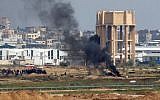 A picture taken on April 6, 2018 from the southern Israeli kibbutz of Nahal Oz across the border from the Gaza strip shows Palestinian men protesting, burning tires. (AFP PHOTO / Jack GUEZ)