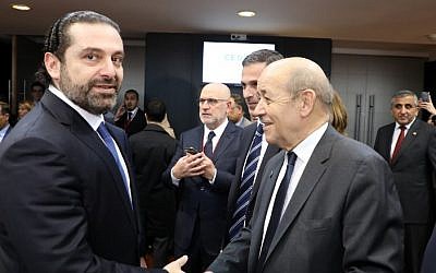 Lebanese Prime Minister Saad Hariri (L) shakes hands with French Foreign Affairs Minister Jean-Yves Le Drian as they attend a conference in Paris on April 6, 2018. (AFP/Pool/Ludovic Marin)