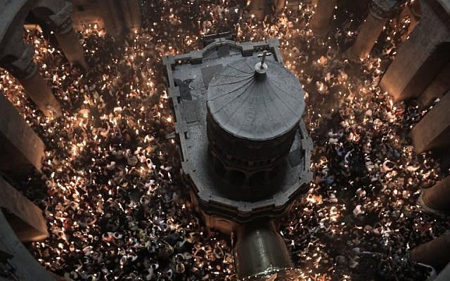 Christian Orthodox worshippers hold up candles during the ceremony of the "Holy Fire" as they gather in the Church of the Holy Sepulchre in Jerusalem's Old City, on April 7, 2018, during Orthodox Easter ceremonies.(AFP PHOTO / MENAHEM KAHANA) Christian Orthodox worshippers hold up candles during the ceremony of the "Holy Fire" as they gather in the Church of the Holy Sepulchre in Jerusalem's Old City, on April 7, 2018, during Orthodox Easter ceremonies.(AFP PHOTO / MENAHEM KAHANA)