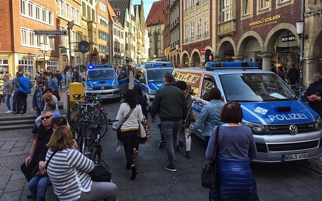 People walk past police cars in Munster, western Germany, where several people were killed and injured when a car plowed into pedestrians on April 7, 2018. (AFP PHOTO / dpa)