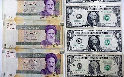 A close up shot shows Iran's various Rial banknotes, bearing a portrait of Iran's late founder of Islamic Republic Ayatollah Ruhollah Khomeini, next to United States one-Dollar bills bearing a portrait of first US President, George Washington at a currency exchange office in a shopping center in the capital Tehran on April 10, 2018. (AFP PHOTO / ATTA KENARE)