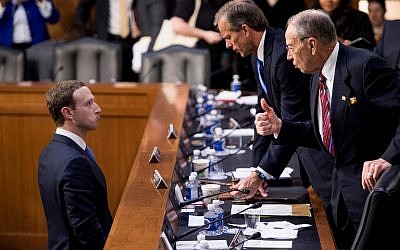 Facebook CEO Mark Zuckerberg (L) speaks with Senator John Thune (C), R-SD, and Senator Chuck Grassley (R), R-IA following a joint hearing of the Senate Commerce, Science and Transportation Committee and Senate Judiciary Committee on Capitol Hill April 10, 2018 in Washington, DC. (AFP PHOTO / Brendan Smialowski)
