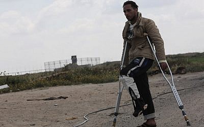 Tamer Abu Daqqa, a Palestinian who says he was shot by an Israeli sniper along the Gaza border during a protest, walks with crutches near the Gaza-Israel border near Khan Yunis in the southern Gaza Strip on April 11, 2018. (AFP PHOTO/SAID KHATIB)