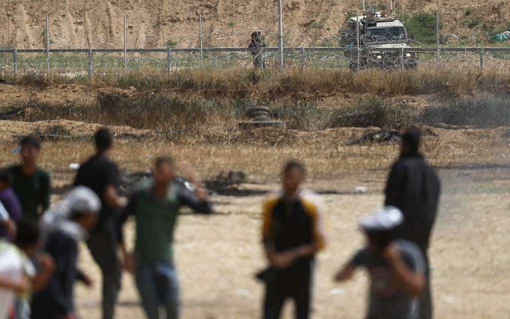 An Israeli soldier aims his weapon as Palestinian protesters gather near the border fence with Israel, east of Khan Yunis in the southern Gaza city on April 13, 2018. (AFP PHOTO / Thomas COEX)