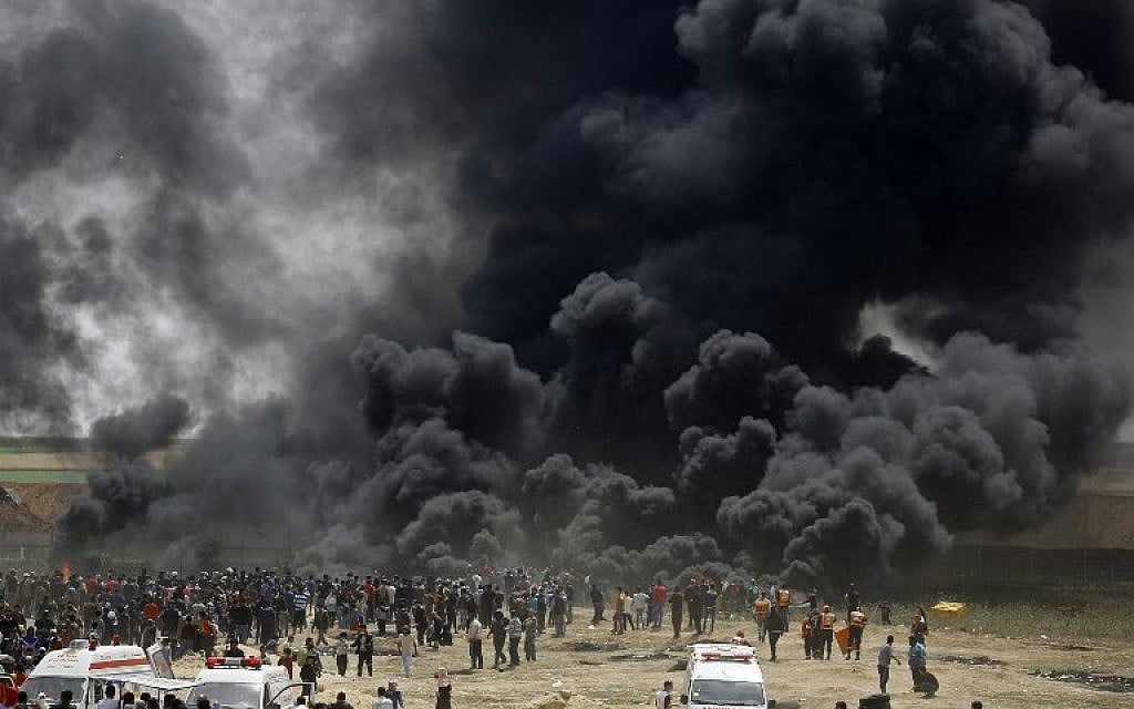 Illustrative: Palestinians burn tires at the border fence with Israel, east of Jabalia in the central Gaza city, during a protest on April 13, 2018.(AFP PHOTO / MOHAMMED ABED)