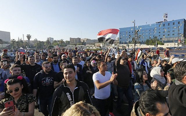 Syrians wave the national flag and wave portraits of President Bashar al-Assad as they gather at the Umayyad Square in Damascus on April 14, 2018, to condemn the strikes carried out by the United States, Britain and France against the Syrian regime. (AFP PHOTO / LOUAI BESHARA) Syrians wave the national flag and wave portraits of President Bashar al-Assad as they gather at the Umayyad Square in Damascus on April 14, 2018, to condemn the strikes carried out by the United States, Britain and France against the Syrian regime. (AFP PHOTO / LOUAI BESHARA)