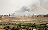 Illustrative: Smoke and flames rise from fields near the Kibbutz Be'eri on the Israeli side of the border with the Gaza Strip east of Gaza City, after Palestinians flew a kite laden with a Molotov cocktail over the border before cutting the string leaving the burning material to fall in Israeli territory on April 17, 2018. (AFP/Mahmud Hams)