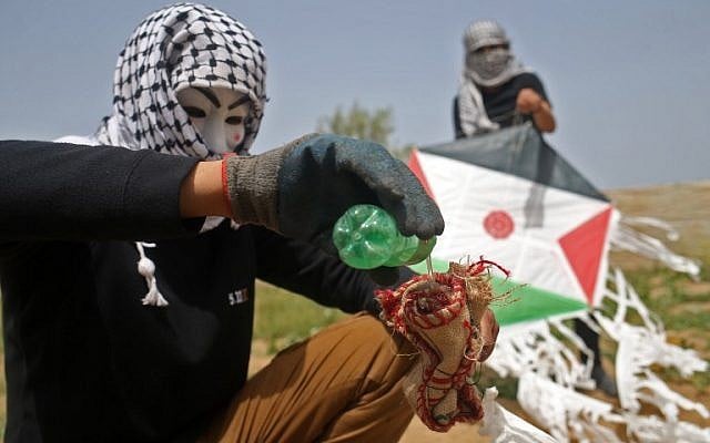 Palestinians on the eastern outskirts of Gaza City prepare a firebomb to attach to a kite and fly over the border fence with Israel, on April 20, 2018. (AFP Photo/Mohammed Abed)