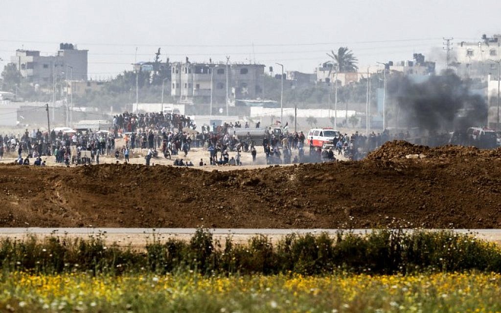 A picture taken from the southern Israeli kibbutz of Nahal Oz across the border with the Gaza Strip shows Palestinians rioting along the border fence on April 20, 2018. (AFP Photo/Ahmad Gharabli)