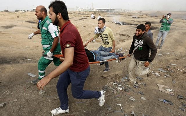 Palestinian medics evacuate a wounded protester during clashes with Israeli forces on April 20, 2018, east of Gaza City (AFP PHOTO / MOHAMMED ABED) Palestinian medics evacuate a wounded protester during clashes with Israeli forces on April 20, 2018, east of Gaza City (AFP PHOTO / MOHAMMED ABED)