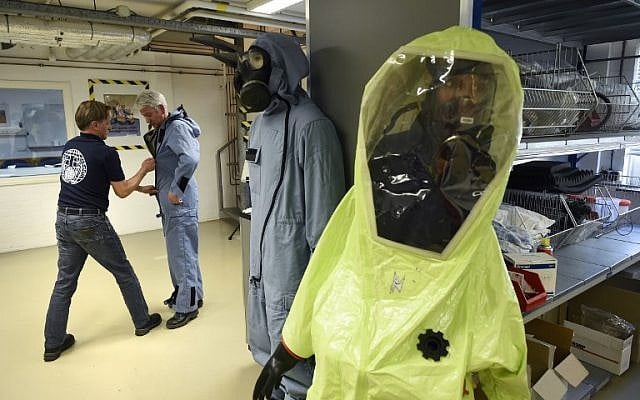 A man tries on an air permeable charcoal impregnated suit, combined with a respirator (or gas mask), rubber boots and three layers of gloves during a simulation at the OPCW (The Organisation for the Prohibition of Chemical Weapons) headquarters in The Hague, The Netherlands, on April 20, 2017. ( AFP PHOTO / JOHN THYS) A man tries on an air permeable charcoal impregnated suit, combined with a respirator (or gas mask), rubber boots and three layers of gloves during a simulation at the OPCW (The Organisation for the Prohibition of Chemical Weapons) headquarters in The Hague, The Netherlands, on April 20, 2017. ( AFP PHOTO / JOHN THYS)