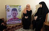 The mother (C) of 15-year-old Palestinian Mohammed Ibrahim Ayoub, who was reportedly shot and killed by the IDF during clashes along the Israel-Gaza border, sits as another person raises his portrait, among other relatives as they mourn in their home in Beit Lahia in the northern Gaza strip on April 21, 2018. (AFP PHOTO / MAHMUD HAMS)