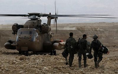 Soldiers walk towards a military helicopter during a search mission for several young people missing in southern Israel after flash floods swept through the area while they were hiking near the Dead Sea on April 26, 2018. (AFP PHOTO / MENAHEM KAHANA)
