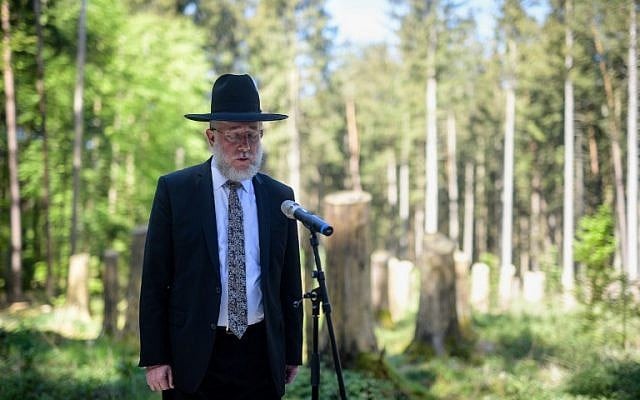 Rabbi Shmeul Aharon Brodman prays the Kaddish during a ceremony to inaugurate a memorial site at the former Muehldorfer Hart concentration camp near Waldkraiburg, southern Germany, on April 27, 2018.
The memorial was inaugurated at the long-forgotten site of a World War II Nazi concentration camp where forced labourers built an aircraft factory deep inside a Bavarian forest. At least 2,200 prisoners, many of them Hungarian Jews, died in the miserable conditions at the Muehldorfer Hart camp and were buried on-site in a mass grave. (AFP PHOTO / dpa / Matthias Balk)