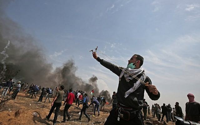 A Palestinian demonstrator uses a slingshot to hurl stones towards Israeli security forces near the southern Gaza Strip town of Khan Younis during the fifth straight Friday of mass demonstrations and clashes along the Gaza-Israel border on April 27, 2018. (AFP Photo/Said Khatib) A Palestinian demonstrator uses a slingshot to hurl stones towards Israeli security forces near the southern Gaza Strip town of Khan Younis during the fifth straight Friday of mass demonstrations and clashes along the Gaza-Israel border on April 27, 2018. (AFP Photo/Said Khatib)