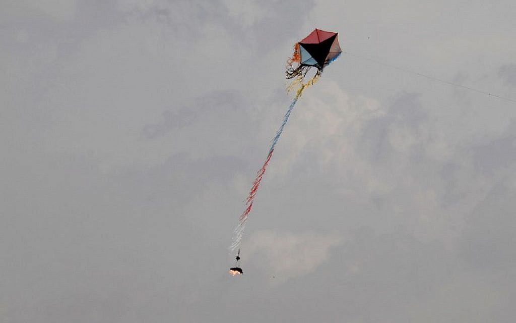 FILE _ Palestinians fly a kite carrying burning materials to set fire to Israeli territory during clashes with Israel troops near Khan Younis in the southern Gaza Strip, during the fifth straight Friday of mass riots along the border between Gaza and Israel, on April 27, 2018. (AFP Photo/Said Khatib)