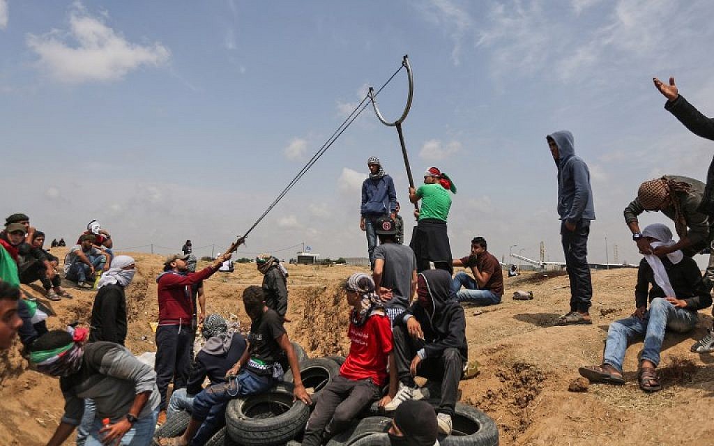 A group of Palestinians man a large sling to hurl stones at Israeli on the border, east of Gaza City in the central Gaza Strip, during the fifth straight Friday of clashes, on April 27, 2018. (AFP Photo/Mahmud Hams)