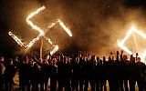 Illustrative: Members of the National Socialist Movement, one of the largest neo-Nazi groups in the US, hold a swastika burning after a rally on April 21, 2018, in Draketown, Georgia. (Spencer Platt/Getty Images/AFP)