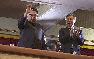 In this April 1, 2018, image from video, North Korean leader Kim Jong Un, left, waves as South Korean Culture, Sports and Tourism Minister Do Jong-whan claps during a performance by a South Korean art troupe in Pyongyang, North Korea.  (Korea Pool via AP)