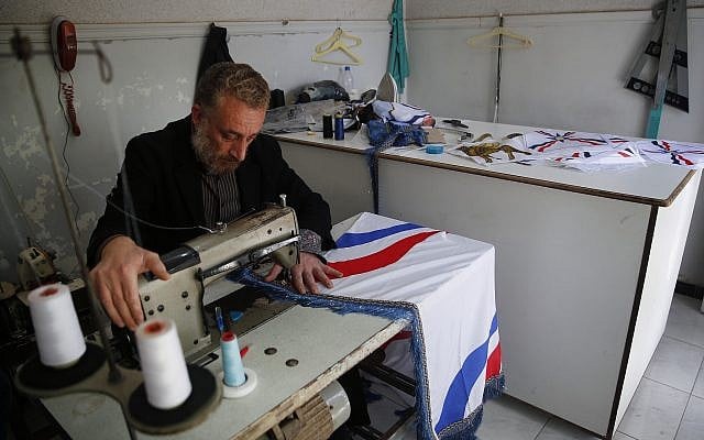 In this April 1, 2018 photo, Dani, an Assyrian Christian tailor, who is also a commander in a local militia, sews his community flag to be used in celebrations of Easter and the Assyrian New Year, or Akitu, in the village of Tal Arboush, northern Syria. (AP Photo/Hussein Malla) In this April 1, 2018 photo, Dani, an Assyrian Christian tailor, who is also a commander in a local militia, sews his community flag to be used in celebrations of Easter and the Assyrian New Year, or Akitu, in the village of Tal Arboush, northern Syria. (AP Photo/Hussein Malla)